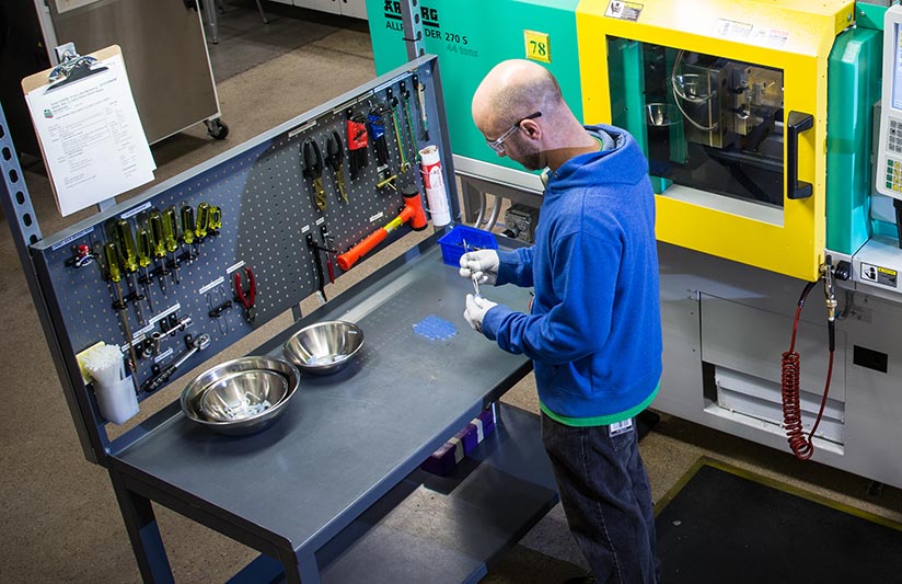 technician cleaning liquid silicone molded part