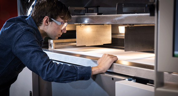 一位应用工程师在尼龙粉末中评估SLS部件