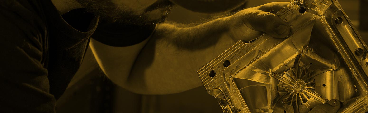 technician examining injection molding block