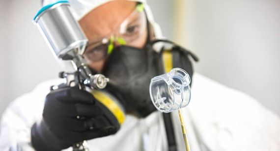 技术员在SLA零件上涂透明涂层