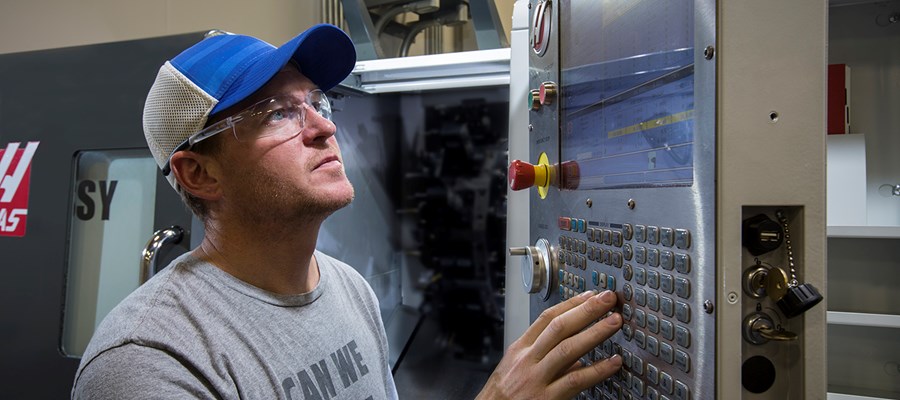 一位工程师在加工零件前检查他的数控铣床上的设置。