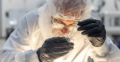 A quality technician examines a plastic part