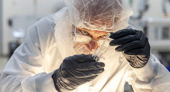 A quality technician examines a plastic part