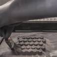 Metal powder is brushed away from a bed of intricate aluminum parts