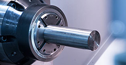 Metal rod stock is firmly fixtured in a high-speed CNC lathe before turning and milling begin