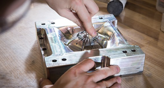 2双手在一个汽车零件桥模具工作