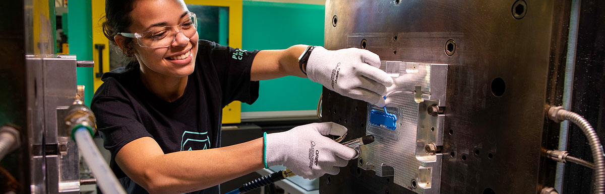 unoperatore rimuove Un pezzo in silicone dalla pressa LSR。