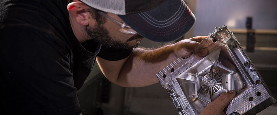 Worker inspecting molded part