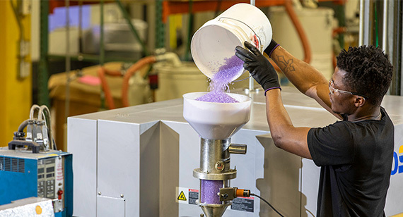 resin pellets being poured into a hopper