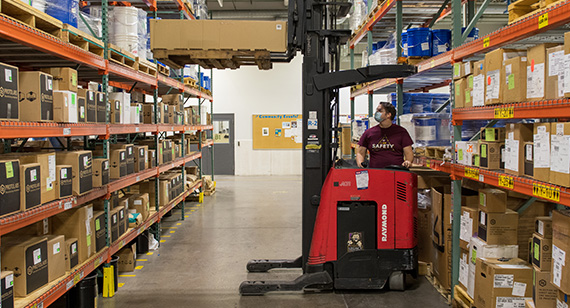 在仓库里用叉车搬运大箱子的工人